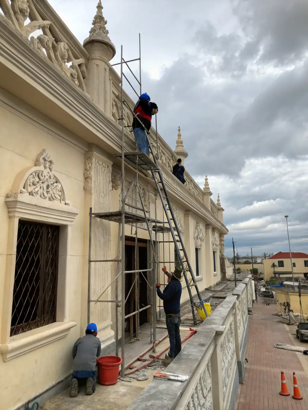 A photograph of the Saint-Thélo church facade undergoing restoration, showcasing scaffolding and workers carefully repairing the stonework.